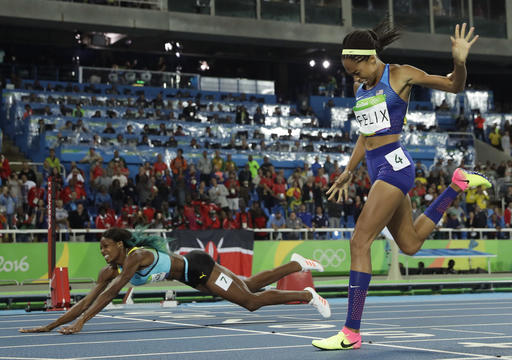 Bahamas' Shaunae Miller falls over the finish line to win gold ahead of United States' Allyson Felix, right, in the women's 400-meter final during the athletics competitions of the 2016 Summer Olympics at the Olympic stadium in Rio de Janeiro, Brazil, Monday, Aug. 15, 2016. (AP Photo/Matt Slocum)