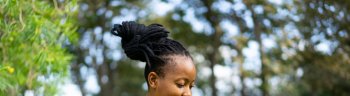 Beautiful african female feeling happy and use smartphone or cellphone with Green background and bokeh