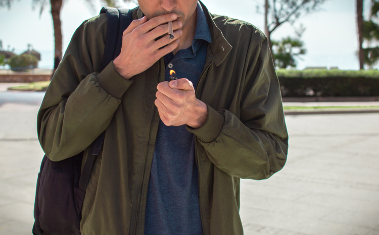 Midsection Of Man Igniting Joint