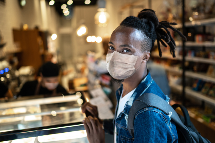 Portrait of young customer with face mask in coffee shop