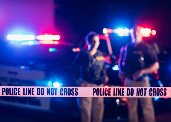 Two police officers standing in front of patrol cars