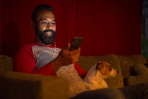 Mixed race man looking at smart phone at home during lockdown