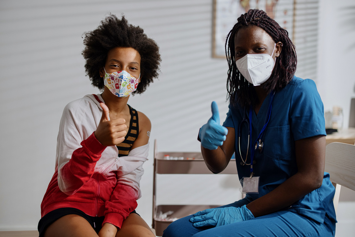 African American pediatrician showing thumbs up with her patient