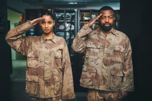 Shot of two soldiers saluting in a server room