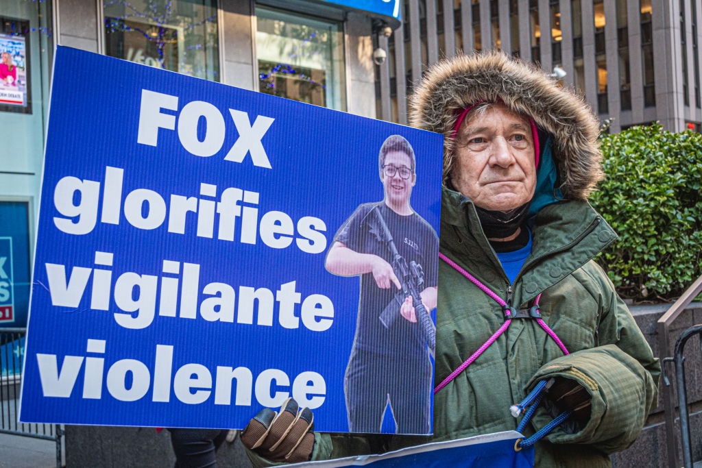 Participant seen holding a sign at the protest. Members of...
