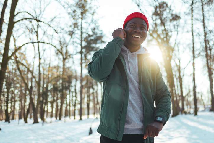 Sportsman putting his headphones in his ears in the park.